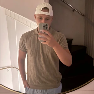 Grön stickad pikétröja från S.C.W - Säljer en grön stickad pikétröja från S.C.W i storlek M. Tröjan har korta ärmar, klassisk krage och v-ringning. Snyggt stickat mönster över hela tröjan ger en stilren och modern look. Perfekt för dig som gillar en clean och avslappnad stil.