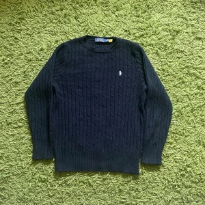  Ralph Lauren tröja - Kabelstickad mörkblå tröja från Polo Ralph Lauren med klassisk broderad logga på bröstet. Skick 10/10 då tröjan endast har använts ett fåtal gånger.