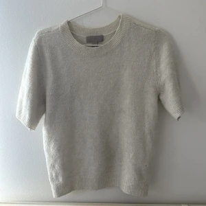 Beige stickad tröja från H&M XS - Supermjuk beige stickad tröja från H&M i storlek XS. Tröjan har korta ärmar, rund halsringning och ribbade muddar vid ärmslut och nederkant. Perfekt för lager-på-lager och enkel att matcha med allt. Priset kan diskuteras