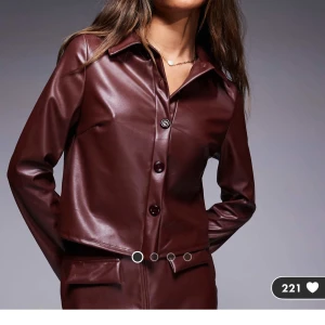 Vinröd skjorta i skinnimitation  - Brun/Vinröd skjorta i läderimitation från Asos. Helt ny med prislapp kvar, del av set. (Säljer även kjolen) Köpt för 409kr.