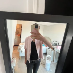 Ljusrosa kofta från Gina Tricot - Säljer en ljusrosa kofta från Gina Tricot i stickad kvalitet. Koftan har korta ärmar, rund hals och knappar framtill i matchande färg. 