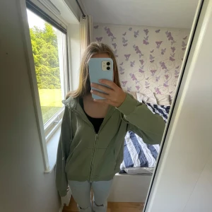 Grön zip tröja från H&M Divided - Säljer en ljusgrön zip tröja från H&M Divided i storlek S. Tröjan har dragkedja framtill, huva och två fickor. Säljer pga jag inte för användning av den