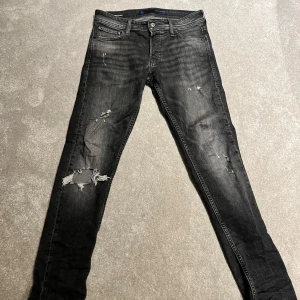 Jack and Jones jeans - Säljer ett par svarta Jack and Jones jeans med slitningar. Modellen är slim och storlek 28/30. Hör av er om minsta fundering💫