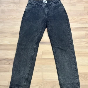 Gråa Jeans från Grunt - Snygga mörkgrå jeans från Grunt i modellen 'Sheat'. De har klassisk femficksdesign, raka ben och hög midja. Jeansen är tillverkade i ekologisk bomull och har en cool tvättad look som ger en avslappnad vibe. Perfekta för dig som gillar streetstyle och vill ha en tidlös jeansmodell.