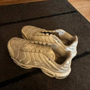 Vita Nike sneakers med vågigt mönster - Nike sneakers i vitt med vågiga detaljer och klassisk Swoosh på sidan. Skorna har snörning och en chunky sula med synliga luftbubblor. Tillverkade i syntet och textil, perfekta för dig som gillar sportig och trendig stil.