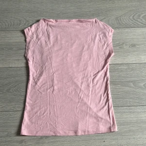 Ljusrosa ärmlös topp i bomull - Hej, jag säljer en rosa topp från lager 157. Den har kortare armar och sitter tajt. Lite skrynklig o lite nopprig på baksidan (som man ser på sista bilden). Använd ett få tal gånger, och är i bra skick.