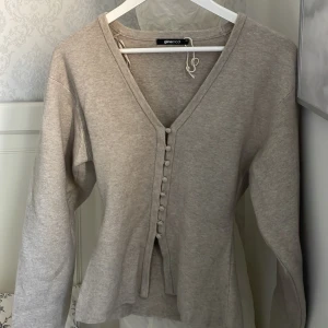 Beige kofta med knappar från Gina Tricot - En super fin kofta/tröja från Gina tricot. Knappt använd 