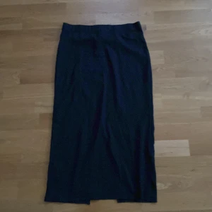 Svart midikjol med slits från 157 - Svart midikjol från 157 i storlek XS. Kjolen har en rak och enkel siluett med en snygg slits baktill som ger extra rörelsefrihet. Du står för frakten, vid mer info skriv