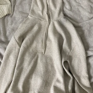Beige ribbad hoodie från Amisu - Mysig beige hoodie från Amisu i ribbstickat material. Tröjan har huva med snörning och långa ärmar, perfekt för chill dagar. Enkel och stilren design som funkar till det mesta. Snyggt oversized vibe och superbekväm att bära.