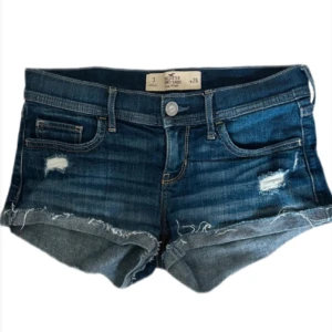 Low waist Hollister shorts  -  Säljer dessa suuupersnygga läg midjade Hollister shorts. De har uppvikta kanter &snygga slitningar. Brodering bak. Köpa pa vinted men storleken passade tyvärr inte mig. Storlek W26 (size 3) midjemätt: 38cm. 26=XS (34) Pris kan diskuteras vid snabb affär!
