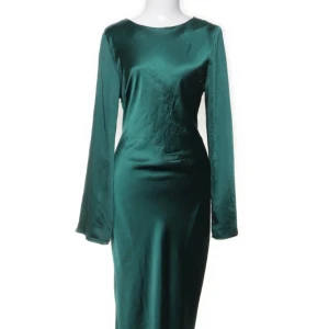 Grön långärmad satinklänning med knyt - Säljer en elegant lång grön klänning i satin med lång ärm och snygg öppen rygg med knyt. Klänningen har en figurnära passform och ett stilrent, slätt tyg som ger en lyxig känsla. Perfekt för dig som vill sticka ut med en cool och sofistikerad look. 
