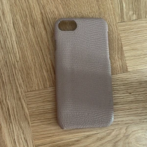 Beige mobilskal med struktur - Säljer ett stilrent beige mobilskal med snygg textur som påminner om lizardmönster. Skalets yta är matt och ger ett lyxigt intryck, perfekt för dig som vill ha en clean look på mobilen.