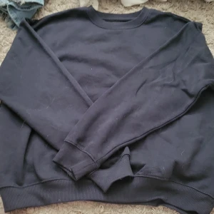 Marinblå sweatshirt - En basic marinblå sweatshirt med rund hals och långa ärmar. Tröjan har ribbade muddar vid ärmslut och nederkant, perfekt för en avslappnad och stilren look. Tillverkad i mjuk bomull som känns skön mot huden.