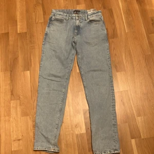 Ljusblå jeans från Tommy Hilfiger -    W 30 Säljer ett par klassiska ljusblå jeans från Tommy Hilfiger med raka ben och normal passform. Jeansen har fem fickor, snyggt Hilfiger-märke på bakfickan och patch i läderimitation vid linningen. Perfekta för en chill och stilren look. Skickas inom en dag vid köp!! Går att pruta ner. Köptes för 1200kr men passar inte längre. Barnstorlek men passar dig i storlek 30W 30 L  storlek 164