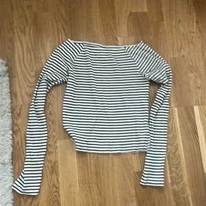 Randig långärmad tröja i bomull - Snygg långärmad tröja med svartvita ränder och klassisk rund hals. Tröjan har en avslappnad passform som funkar perfekt till jeans eller kjol. Enkel och stilren design som aldrig går ur tiden. Finns ingen storlek eller lapp men typ xs