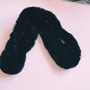 Svart fluffig fuskpäls halsduk - Mysig svart halsduk i fluffig fuskpäls som ger en lyxig känsla. Perfekt att slänga över jackan när det är kallt ute. Enkel design utan mönster, passar dig som gillar stilrena accessoarer.  Helt & fint skick