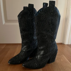 Cowboy boots - Svarta cowboy boots med snygga detaljer i storlek 37, endast använda en gång så i väldigt bra skick! 