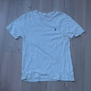 Vit t-shirt från Polo Ralph Lauren: Etikett borttvättad… - Vit t-shirt från Polo Ralph Lauren med klassisk broderad logga på bröstet. T-shirten har rund halsringning och korta ärmar. Tillverkad i mjuk bomull för en skön känsla och enkel stil.