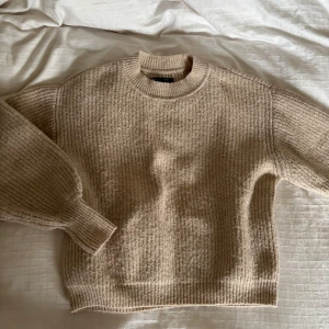 Beige stickad tröja från ASOS DESIGN - Mysig beige stickad tröja från ASOS DESIGN med grov struktur och ribbade muddar vid ärmslut, hals och nederkant. Lite nopprig men i övrigt bra skick 