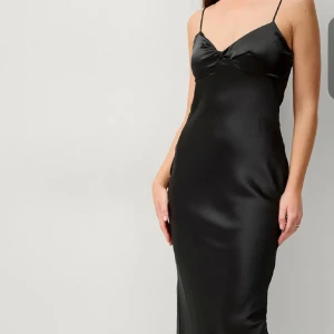 Svart satinklänning med smala axelband - Supersnygg svart långklänning i satin med smala axelband och lätt v-ringad byst. Klänningen har en figurnära passform och slits baktill för extra rörelsefrihet. Perfekt för dig som vill ha en stilren och elegant look. För liten för mig nu tyvärr😢❤️