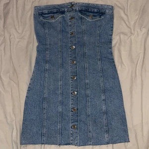 Blå jeansklänning från Gina Tricot - Snygg blå jeansklänning med knappar från Gina tricot i storlek S. Aldrig använd, köpt för något år sedan.