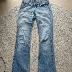 Ljusblå bootcut jeans  - Säljer ett par ljusblå lowrise jeans. Midjemåttet 35. Grenhöjd - 17cm. Innerbenslängden - 81