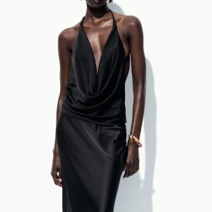 Svart halterneck topp från Zara - Supersnygg svart halterneck topp i satin med öppen rygg. Köpte den för någon vecka sedan men säljer då den inte är min stil. Helt oanvänd, storlek S💞💞💞