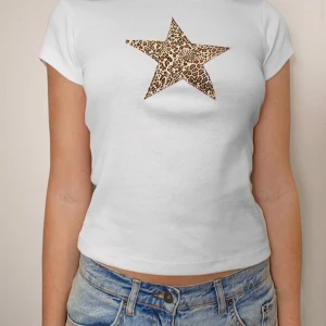 Vit t-shirt med leopardstjärna Subdued - Vit t-shirt från Subdued i bomull med en stor stjärna i leopardmönster på bröstet. Modellen är kortärmad och har en klassisk rund halsringning. Perfekt för dig som gillar en clean look med en cool twist.
