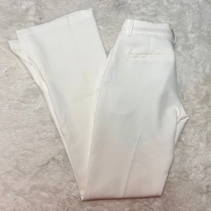 Lågmidjade vita kostymbyxor bikbok  - Storlek 34 från bikbok. Använda max 4 gånger. Nypris låg på någonstans mellan 400-500kr. Slits i benen. Innerbenslängd:80 midjemått:33 strech på några cm när man väl har på sig de. Har inga fler bilder på då de blivit försmå. Köp sker via köp nu, jag postar inom 24h. Kvar tills markerad såld 