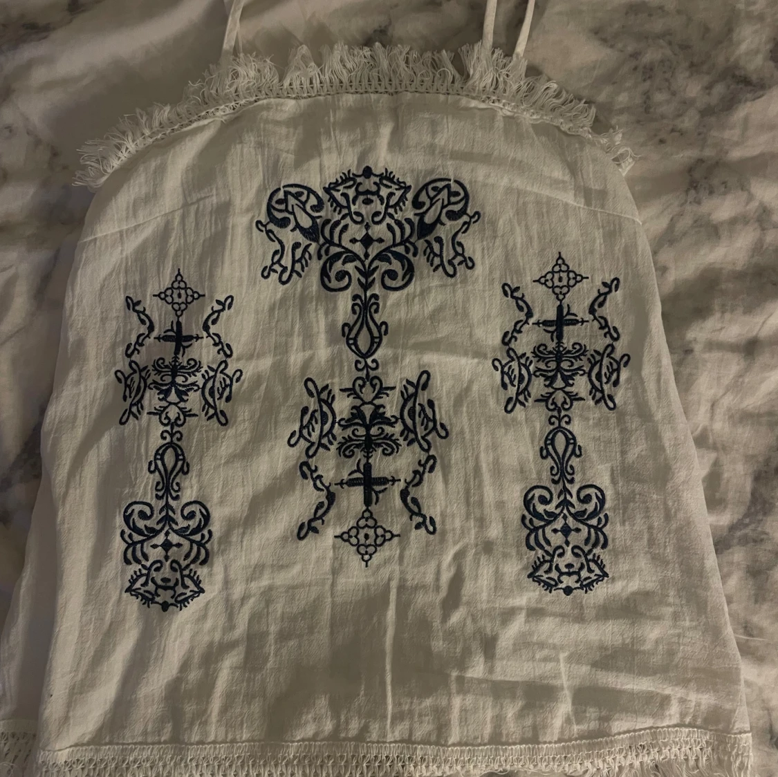 Vit linnetopp med blå broderi