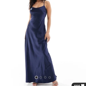 Marinblå långklänning från ASOS - Snygg marinblå långklänning i satinliknande material med smala axelband och öppen rygg. Klänningen har en stor rosett bak och ett elegant, figurnära fall. Perfekt för dig som vill sticka ut med en stilren och trendig look. Helt oöppnad, ursprungspris 1139💗