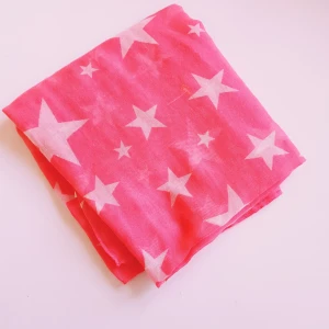 Rosa halsduk med vita stjärnor - Snygg och tunn rosa halsduk med vita stjärnor över hela tyget. Perfekt accessoar för att liva upp din outfit. Gjord i 100% polyester och har en lätt och luftig känsla. Enkel att styla och passar året runt.  Små tråddragningar men inga hål & annars helt & fint skick