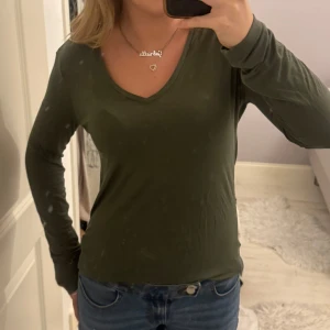 Khaki Långärmad topp - Topp med en superfin grön, khaki färg, tunt hudnära material, från cubus. Använd ett fåtal gånger! Passar uppskattningsvis XS-M!🩷
