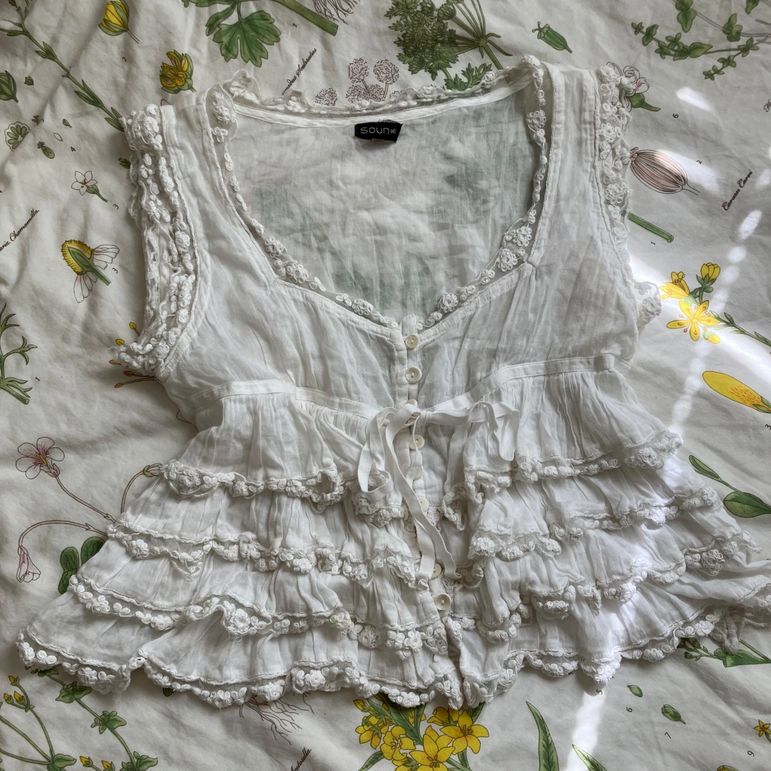 Vit blus med volanger och rosett 