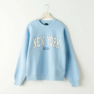 Ljusblå sweatshirt - Ljusblå sweatshirt med stort vitt New York-tryck och texten EE.UU på bröstet. Tröjan har rund hals, ribbade muddar och en loose passform. Perfekt för dig som gillar en chill och avslappnad stil.
