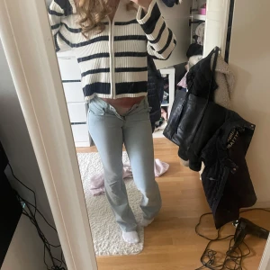 Ljusblå bootcut jeans från Mudd - Säljer ett par ljusblå jeans från Mudd  med bootcut passform. Jeansen har klassiska bakfickor med Replay-logga och är tillverkade i mjukt denimtyg. Snygg låg midja och utsvängda ben ger en trendig siluett.
