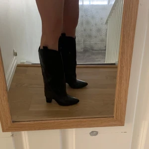 Svarta höga cowboy boots med klack - Snygga svarta boots i skinnimitation med spetsig tå och hög blockklack som gör att de är väldigt stabila. Perfekta för att lyfta vilken outfit som helst! Älskar dessa skor men säljer då jag har för många liknande💕