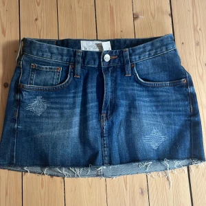 Snygg jeanskjol  - Snygg blå lågmidjad jeanskjol från H&M. Kjolen har slitna detaljer men är i fint skick! 💓 Hör av er vid funderingar 😇