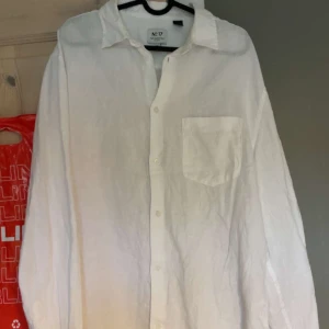 Vit linneskjorta från H&M Essentials - Klassisk vit skjorta i linne från H&M Essentials, modell Regular Fit. Skjortan har lång ärm, bröstficka och knäppning framtill. Perfekt för en clean och stilren look, passar lika bra till jeans som till shorts. 100% linne