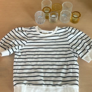 Randig tröja från Holly & White - Vit och svart randig tröja från Holly & White med puffiga trekvartsärmar och breda muddar. Tröjan har en avslappnad passform och är gjord i mjuk bomull, perfekt för en chill och stilren look. Nästan aldrig använd, säljer pågrund av att jag aldrig använder den