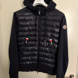 Moncler Cardigan Navy - Moncler Cardigan med luva, navy i storlek M. Väldigt fint skick. Nypris runt 10 000kr