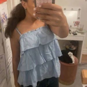 Ljusblå volangig linnetopp - Supersöt ljusblå linnetopp med tunna axelband och flera lager volanger. Väldigt ny! Har storlek S o den passar mig! 