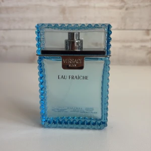 Versace Man Eau Fraîche parfym 100ml - Fräsch och maskulin parfym från Versace, Eau Fraîche. Flaskan är rektangulär med taggig blå ram och silverdetaljer. Parfymen kommer i en stilren blå kartong med mönster och silvertext. Volym: 100 ml. Perfekt för dig som gillar en lätt och modern doft.
