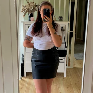 Svart kort kjol i skinnimitation H&M - Säljer en svart kort kjol från H&M i skinnimitation med snygg dragkedja i sidan. Kjolen har en tight passform och är gjord i polyester med polyuretanbeläggning. Använd en gång!🌸 Storleken är liten, mer som en L istället!🌼