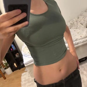 Grön kortärmad topp från 157.NBN - Säljer en stilren grön kortärmad topp från 157.NBN. Toppen har en tight passform och är tillverkad i ett mjukt material som sitter skönt mot kroppen. Perfekt för en avslappnad look.