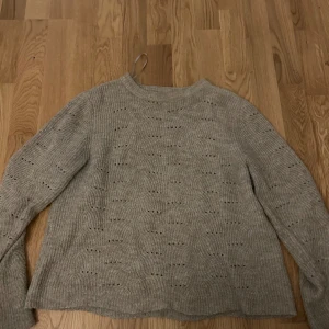 Beige stickad tröja - Säljer en mysig beige stickad tröja med lång ärm. Tröjan har ett diskret hålmönster och en rund halsringning. Perfekt för kyligare dagar!