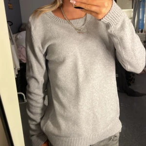 Grå tröja från VILA - Säljer en stilren grå tröja från VILA. Tröjan har en normal passform med långa ärmar och ribbade muddar vid ärmslut och nederkant. Perfekt för en avslappnad look.