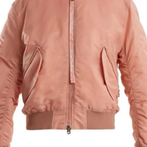 Rosa bomberjacka från Acne Studios - Säljer en snygg rosa bomberjacka från Acne Studios. Jackan har en dragkedja framtill och ribbade muddar vid ärmslut och nederkant. Den är quiltad på insidan för extra komfort och stil. Perfekt för att ge din outfit en cool touch!