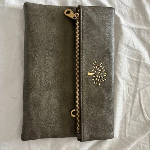 Mulberry liknande clutch  - Supersnygg grå mulberry liknande ”clutch” väska! Väldigt bra skick och har många dragkedjor🩵
