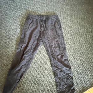 Svarta mjukisbyxor från H&M - Säljer ett par svarta mjukisbyxor från H&M i storlek M. Byxorna har en elastisk midja med snörning för justerbar passform. Perfekta för en avslappnad stil. Linnemix. Något noppiga på insidan men inga andra problem. Nypris ca 400